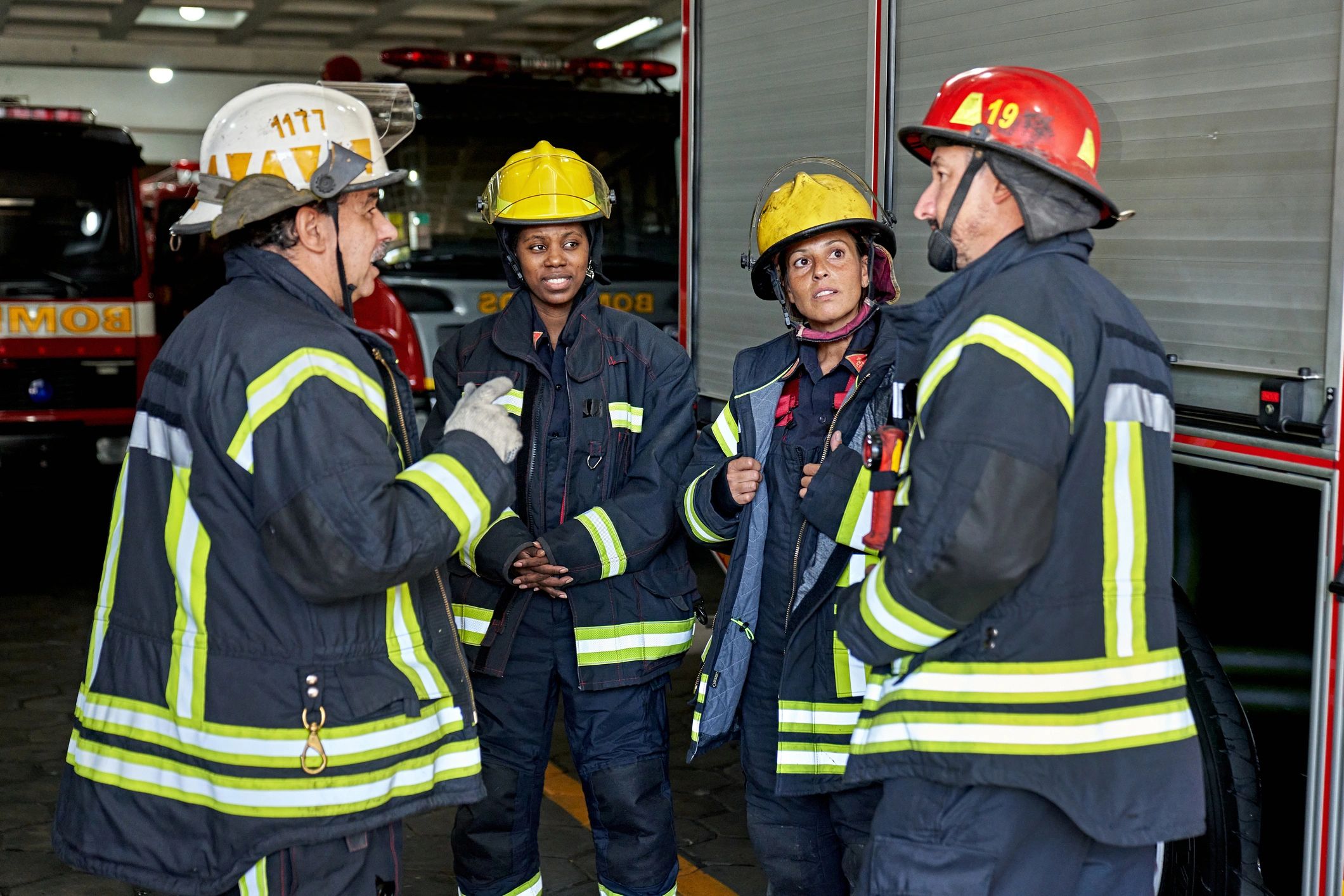 Fire company officer speaking with firefighters in the station garage before deployment